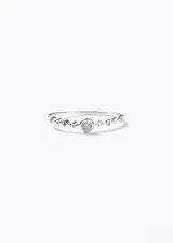 Anillo de plata 925 con diseño de banda fina adornada con pequeñas zirconias engastadas y una zirconia central de 4mm.