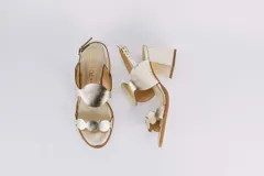 Sandalias plateadas de cuero con taco ancho y diseño de ondas en el empeine. Cierre con hebilla en el tobillo.