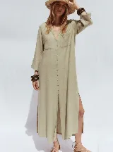 Vestido camisero blanco confeccionado en lino, de corte recto y largo midi. Presenta cuello camisero, mangas 3/4 con puños abotonados, cierre frontal con botones y abertura en el ruedo.