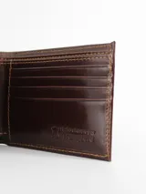 Billetera de cuero premium color marrón oscuro, con doble tarjetero y costuras en contraste.