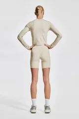 Bikers deportivas color crema de tejido funcional DryMove™ con cintura ancha de tiro alto y bolsillo abierto en una pierna.