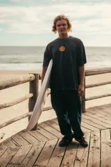 Remerón negro con efecto lavado y estampado en la espalda con la inscripción "Classy Waves" en color naranja.