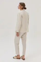 Blazer color crema de lino metalizado con bordado de hilo metálico en las solapas delanteras.