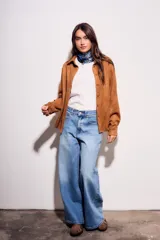 Camisa color marrón de gamuza sintética, de corte recto, con cuello clásico, cierre frontal con botones y mangas largas.