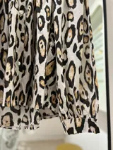 Camisa de manga larga con cuello mao y estampado animal print en tonos crudo, negro y marrón.