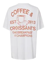 Remera blanca de calce oversize, cuello redondo y mangas cortas. Estampado pequeño en el pecho de un croissant mordido.