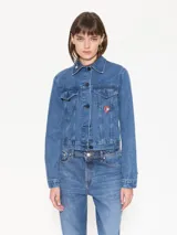 Campera de jean azul de calce estándar con bordados y parches de figuras emblemáticas del artista Edgardo Giménez.