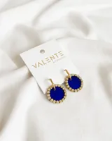 Par de aros colgantes con forma circular, de color azul con borde dorado y pequeños brillantes. El aro es dorado y fino.