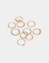 Set de 10 anillos dorados de metal con diferentes diseños, algunos con perlas y otros con strass.