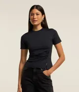 Blusa negra ajustada de microfibra con cuello redondo y mangas cortas. Presenta fruncido en el lateral y encaje en el bajo.
