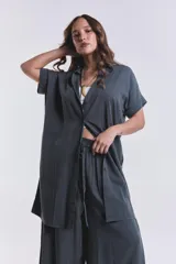 Camisola verde grisáceo de tencel con cuello camisero, mangas cortas con dobladillo y cierre frontal con botones.