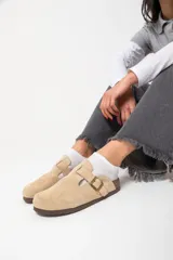 Zuecos de cuero con hebilla ajustable y base de corcho.