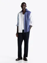 Camisa de manga larga con diseño color block en azul y blanco, confeccionada en algodón Oxford, con cuello abotonado, bolsillo de parche en el pecho, puños redondeados con botón y logo bordado en el bolsillo.
