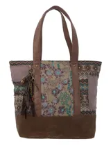 Bolso tipo tote con estampado floral y geométrico en tonos marrones, beige, verde y lila. Cuenta con asas de cuero sintético marrón y un dije decorativo con borlas.