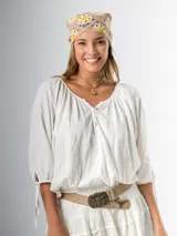 Blusa color crudo de algodón suave, con mangas 3/4 abullonadas con ajuste de cinta, botones frontales en el escote y elástico flojo en la cintura.