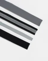 Set de cuatro vinchas elásticas deportivas de distintos anchos y colores: gris oscuro, negro con tres líneas blancas, gris claro y negro liso.