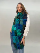 Bufanda de lana merino con diseño geométrico de cubos en tonos de gris y negro.