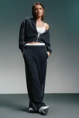 Conjunto deportivo azul marino con detalles de ribete blanco. Incluye una campera corta con cierre y un pantalón de corte recto.