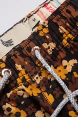 Short de baño con estampado floral en tonos marrones y amarillos, con cintura elástica ajustable con cordón.