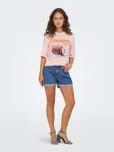 Remera rosa de algodón con estampado de cocos y texto en color naranja.