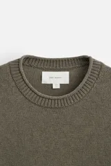 Jersey color beige de punto con cuello redondo y manga larga.
