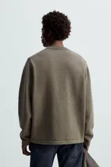 Sweater color verde oliva de punto con cuello redondo y manga larga.