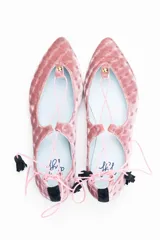 Bailarinas de terciopelo de seda rosa con diseño anudado al tobillo, trasera de terciopelo negro y borlas de ante negro. Incluye plantilla de piel y plantilla extra de lana intercambiable.