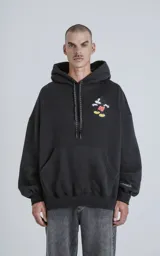 Buzo negro con capucha, calce oversize y estampado de Mickey Mouse en el pecho.