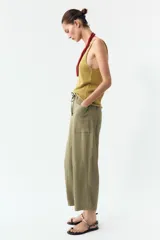 Pantalón color verde oliva de tiro alto, corte ancho y largo 7/8. Tiene cintura elástica ajustable con cordón, bolsillos de plastrón en delantero y espalda.