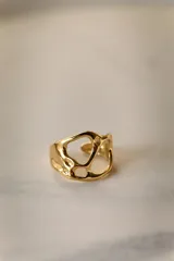 Anillo ajustable de acero quirúrgico hipoalergénico, color dorado, con diseño orgánico y calado.