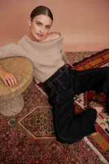 Pantalón negro de tiro alto y corte palazzo, con bolsillos laterales y pespuntes en color crudo.