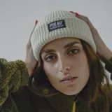 Gorro de lana blanco con etiqueta negra con el logo de la marca Pulau.