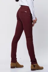 Pantalón de gabardina gris oscuro, corte skinny, con bolsillos delanteros y traseros. Se ajusta a la cintura con cinturón de cuero marrón con hebilla dorada.