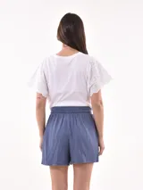 Short celeste de tejido arrugado con cintura elastizada y lazo de ajuste.