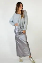 Falda midi color plateado metalizado, de corte recto con tajo en la espalda. Presenta detalles de costura que simulan bolsillos traseros.