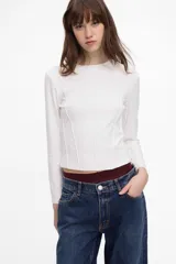 Remera de algodón suave, entallada, con mangas largas y cuello redondo, con detalles de costuras.