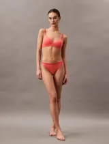 Conjunto de ropa interior color salmón, compuesto por un corpiño sin aro de microfibra suave con breteles finos regulables y una bombacha tipo tanga.