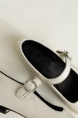 Zapato estilo Mary Jane color marrón, de cuero, con punta redondeada y tira sobre el empeine con hebilla.