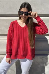 Sweater negro de tejido de punto con escote en V y rayas verticales plateadas.
