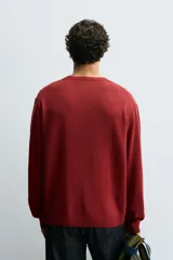 Jersey de hombre color borgoña, de corte holgado, tejido en hilatura con mezcla de algodón. Cuello redondo y manga larga. Acabados en rib.