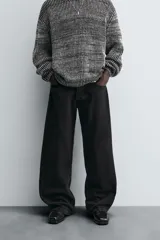 Pantalón de jean negro de corte amplio, estilo balloon fit, con cinco bolsillos y cierre frontal con botones.