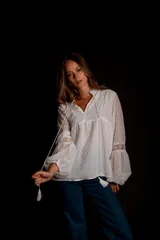 Camisa blanca de plumetí con cuello mao, mangas largas abullonadas con puños elásticos y cordón con borlas en el escote.