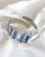 Brazalete rígido plateado con cinco piedras de cianita azul.