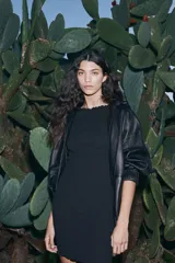 Vestido corto negro entallado de punto con textura arrugada y escote barco.
