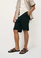 Bermuda de gabardina color verde con bolsillos laterales tipo cargo.