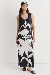 Vestido largo de seda con estampado floral abstracto en blanco sobre fondo negro, escote redondo y corte recto.