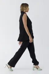 Pantalón negro de vestir de corte palazzo con cintura alta y bolsillos laterales.