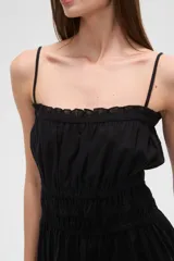 Vestido corto negro de algodón con breteles finos, escote recto, corte holgado, cintura elastizada y volados en el ruedo.