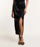 Vestido midi negro de satén con escote halter y abertura lateral.