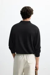 Polo de punto azul marino de corte regular fit, tejido en hilatura con mezcla de algodón y seda. Tiene cuello solapa con cierre frontal de botonadura, manga larga y acabados en rib.